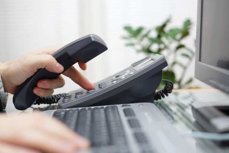 view of hands holding phone and on a keyboard